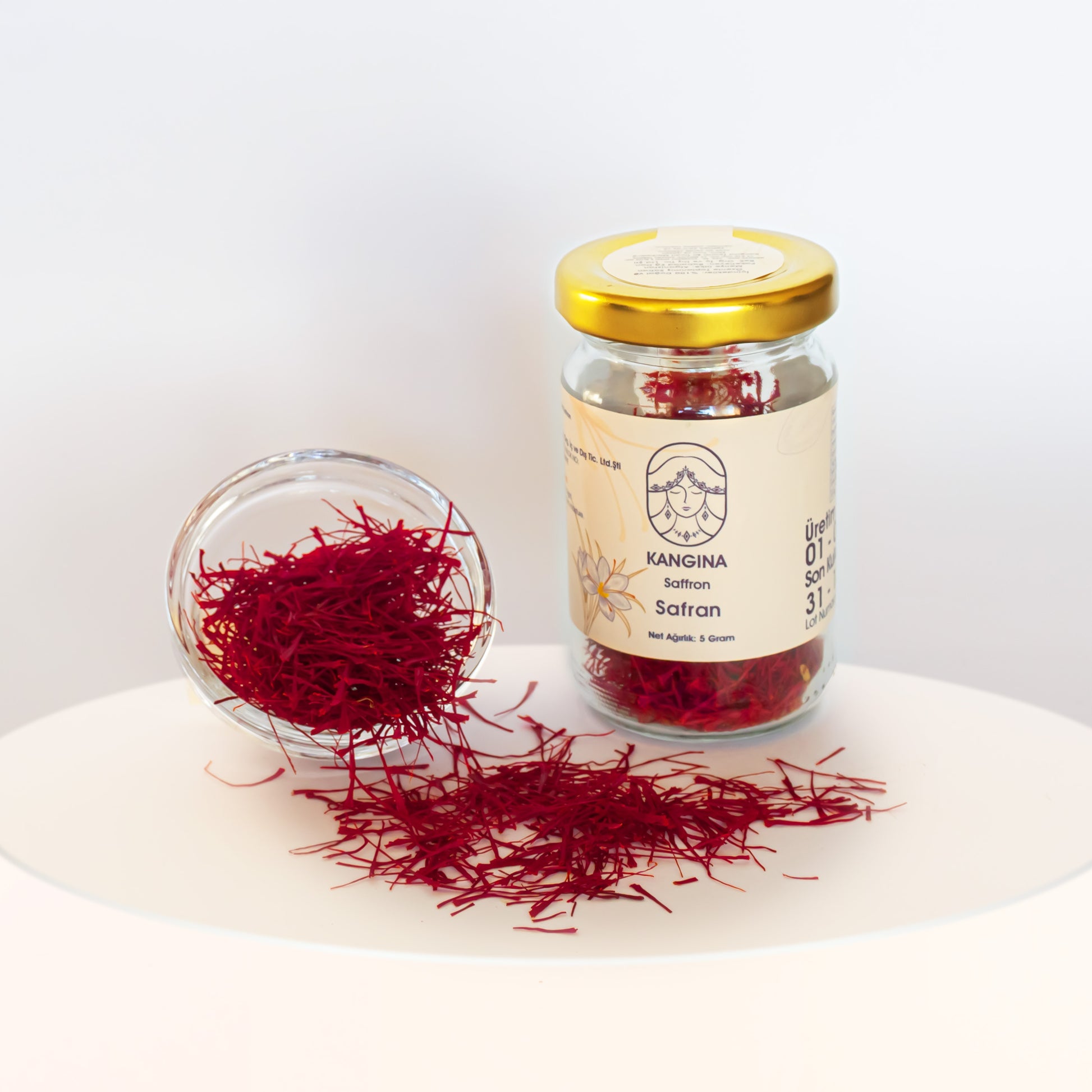 Kangina premium Afghan saffron threads – 5 g jar next to a clear bowl overflowing with bright saffron threads