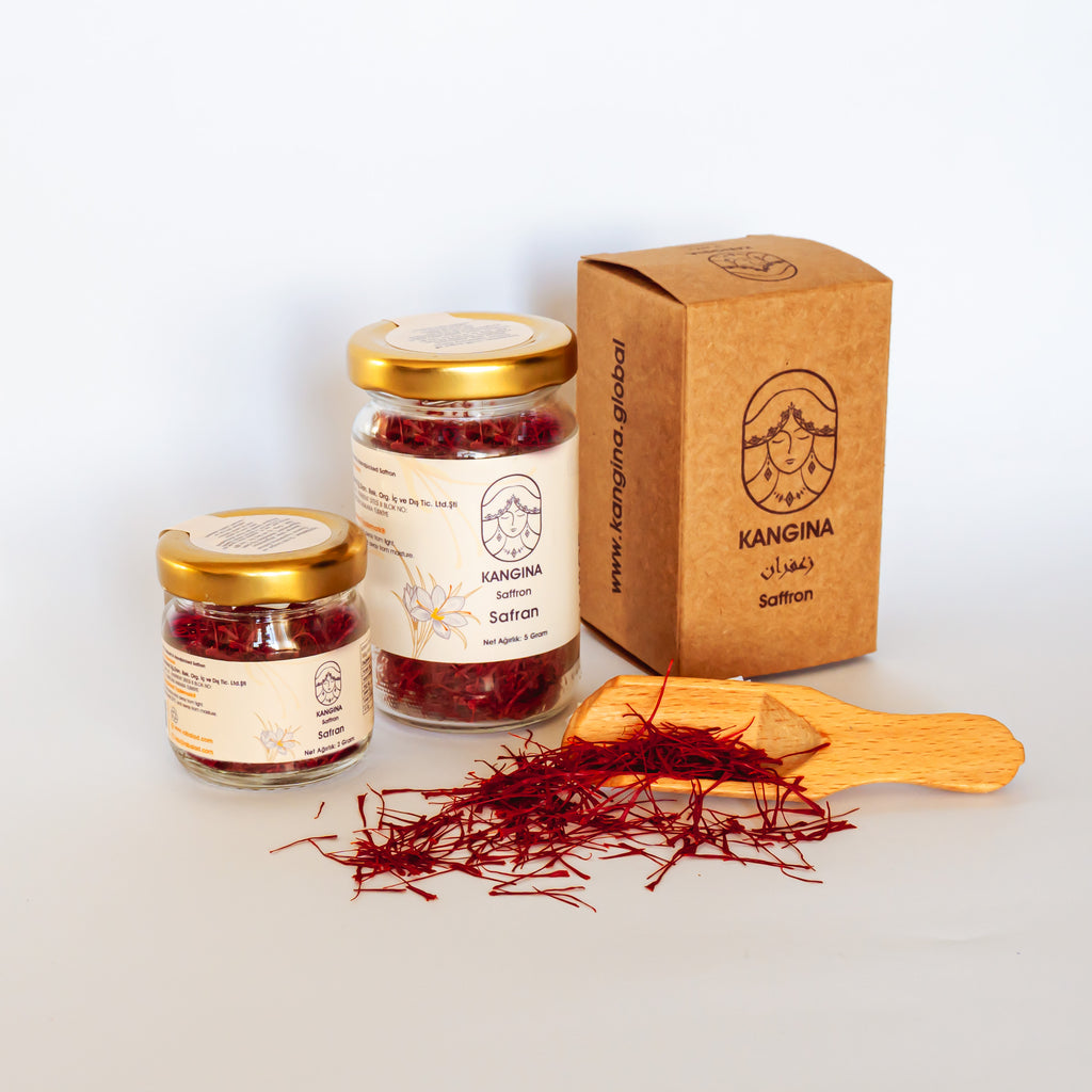 Two Kangina jars, kraft gift box and wooden scoop with fresh threads arranged together for product family shot
